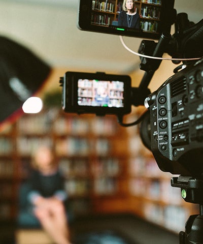 A video camera and viewfinder with the subject of the video in the background